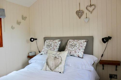 two beds in a bedroom with hearts on the wall at Hare's Hut in Saint Clement