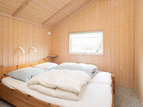 a bedroom with two beds in a wooden wall at Holiday home Slagelse XX in Slagelse
