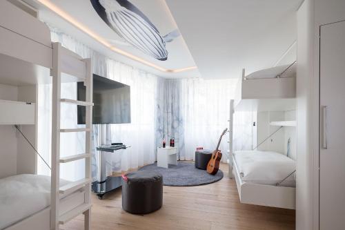 a bedroom with two bunk beds and a guitar at Neuro Campus Hotel in Vitznau
