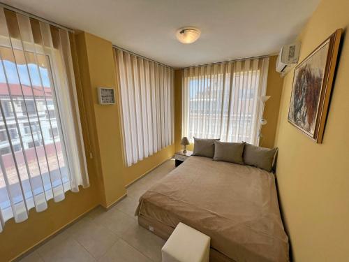 a bedroom with a bed and a large window at Valemar Apartments in Pomorie