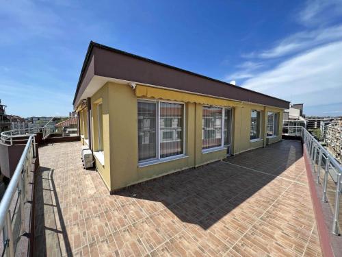 a house on a deck with a balcony at Valemar Apartments in Pomorie