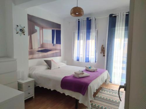 a bedroom with a bed with a purple blanket at Apt VILLA CUDILLERO recep P Isabel in Cudillero
