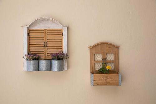 a wall with two flower pots and a window at Rania Studios in Gouves