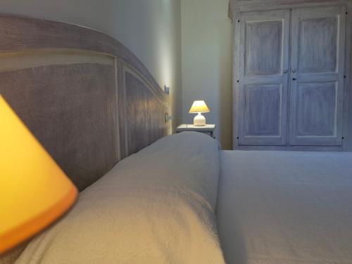 a bedroom with a large bed and a lamp at La Corte degli Ulivi - Albergo Rurale in Tresnuraghes