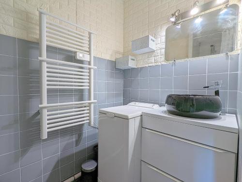 une salle de bain blanche avec un lavabo et un miroir dans l'établissement Appartement proche port et mer avec wifi et climatisation, au Cap d'Agde
