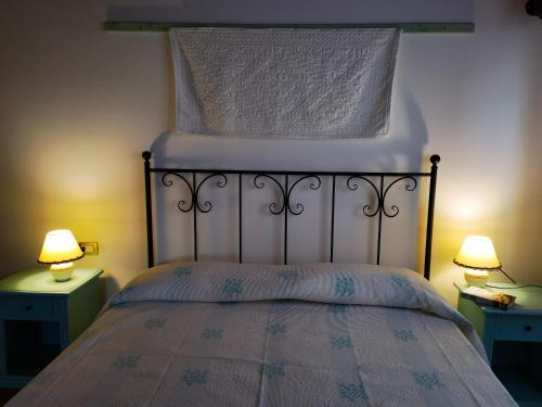 a bedroom with a bed with two night stands and two lamps at La Corte degli Ulivi - Albergo Rurale in Tresnuraghes