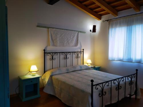 a bedroom with a large bed with two night stands at La Corte degli Ulivi - Albergo Rurale in Tresnuraghes
