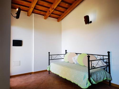 a bedroom with a bed in a room with white walls at La Corte degli Ulivi - Albergo Rurale in Tresnuraghes