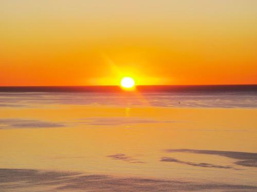 a sunset over the ocean with the sun setting at La Corte degli Ulivi - Albergo Rurale in Tresnuraghes