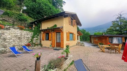 a small house with blue chairs and a patio at vallemaira house "Chalet Le Terrazze" 2-12 Persone in exclusiva da 2 persone in San Damiano Macra