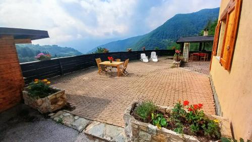 a patio with a table and chairs on a balcony at vallemaira house "Chalet Le Terrazze" 2-12 Persone in exclusiva da 2 persone in San Damiano Macra