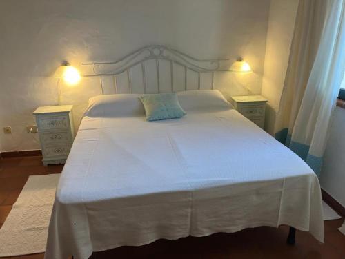 a bedroom with a white bed with two night stands at Angelo e Arcangela in Telti