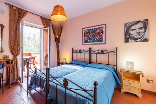 a bedroom with a bed with a blue comforter at La Tana delle Stelle B&B di Charme e Relax in Fara in Sabina