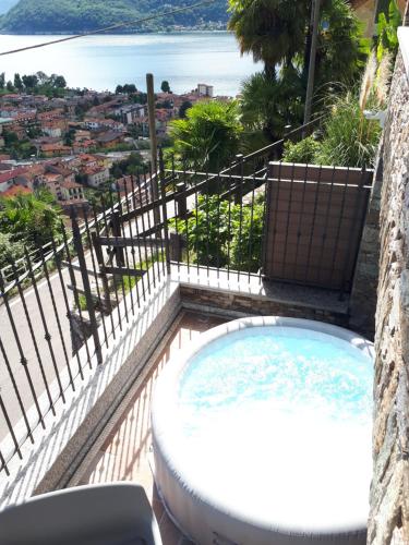 a hot tub on a balcony with a view of the ocean at Sole & Lago-Lake in Maccagno con Pino e Veddasca