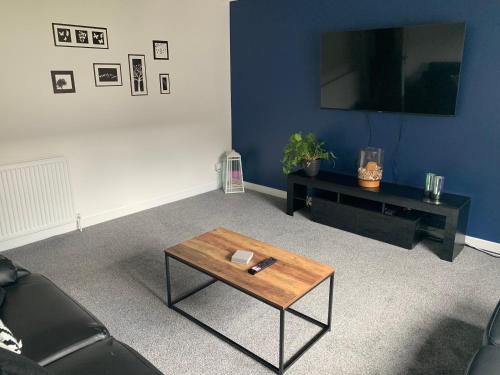 a living room with a coffee table and a tv at Dumfries Apartment in Dumfries