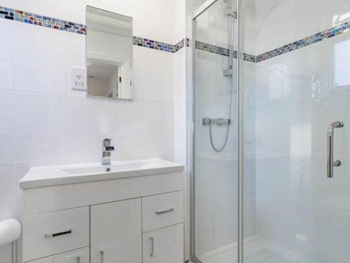 a white bathroom with a sink and a shower at Lovely Period Cottage sleeps 4 resting in Torquay in Torquay
