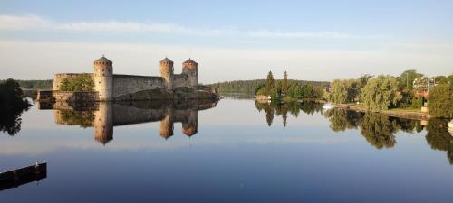 un château installé au-dessus d'une étendue d'eau dans l'établissement Mäntylinna, à Savonlinna
