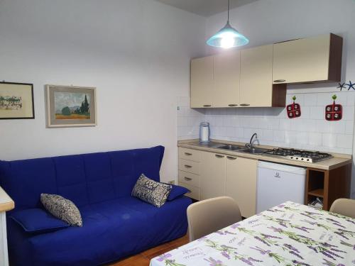 un soggiorno con divano blu e una cucina di Stella Maris a Santa Teresa di Gallura
