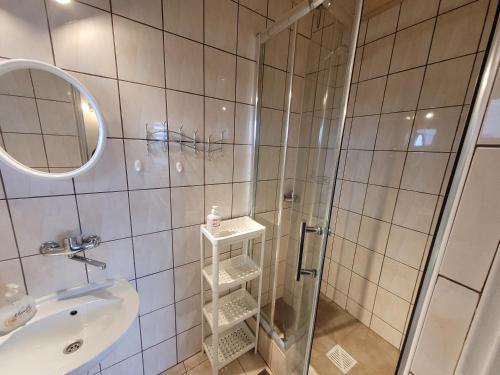 a bathroom with a shower and a sink at Pokoje Goscinne ANNA in Ostrowo