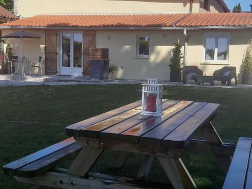 a wooden picnic table with a candle on top of it at Gîte L'Ecureuil*** in MouscardÃ¨s