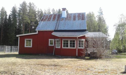 une maison rouge avec un toit en étain au-dessus dans l'établissement Villa Polarktis, à Överkalix