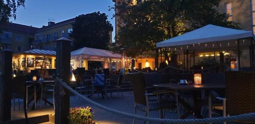 an outdoor restaurant with tables and chairs at night at Hotel Hospitz in Savonlinna