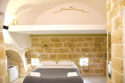 una camera con un letto in una parete in pietra di Minuetto 54 a Ostuni