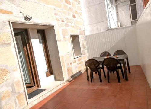 a dining room table with chairs and a patio at O LAR DE MARTINA in Redondela