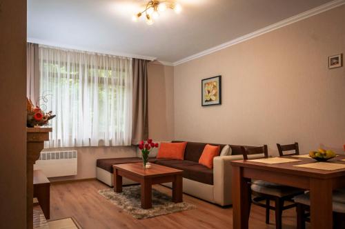 a living room with a couch and a table at Lusi Holiday, Смолянски езера in Smolyan