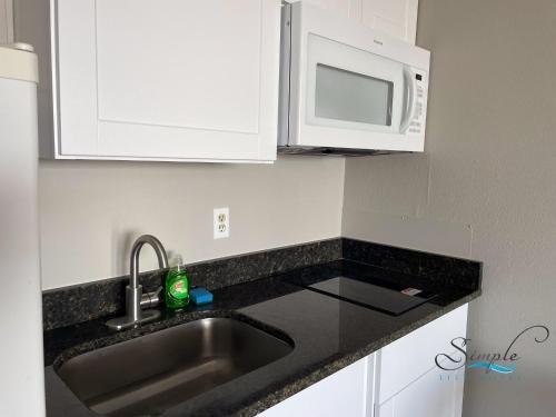 a kitchen with a sink and a microwave at Simple Life Motel in Ocean City