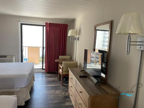 ein Hotelzimmer mit einem Bett und einem Flachbild-TV in der Unterkunft Simple Life Motel in Ocean City