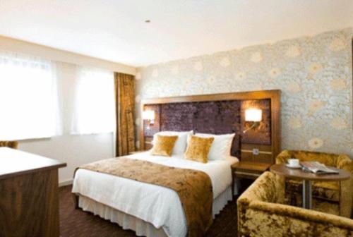 ピーターヘッドにあるBuchan Braes Hotelの大きなベッドとソファが備わるホテルルームです。