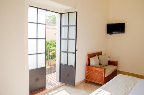 Hotel Catedral في كويرنافاكا: غرفة نوم بسرير وباب زجاجي منزلق