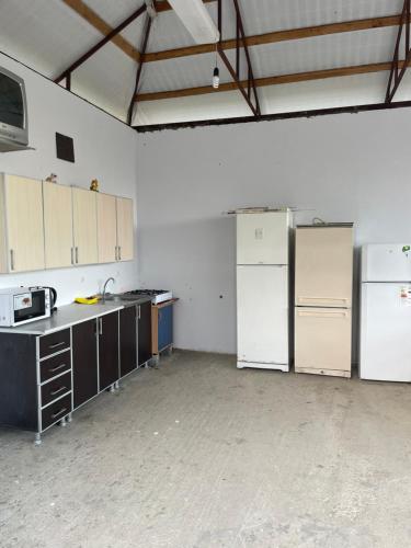 an empty kitchen with white appliances in a room at At Alla's in Novy Afon