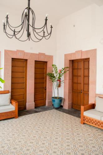 a room with three wooden doors and a potted plant at Hotel Catedral in Cuernavaca