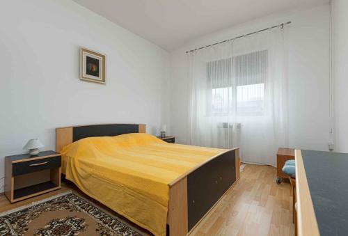 a bedroom with a bed with a yellow bedspread at Apartment in Porec/Istrien 10190 in Poreč