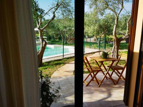 a patio with a table and chairs and a pool at La Corte degli Ulivi - Albergo Rurale in Tresnuraghes