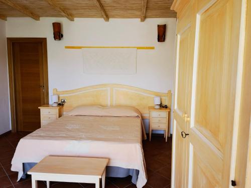 a bedroom with a bed and a table at La Corte degli Ulivi - Albergo Rurale in Tresnuraghes