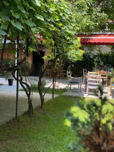a yard with chairs and a table and trees at Grand Boutique Hotel in Pristina