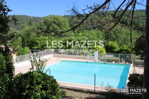 a swimming pool with a sign that reads las markets greenhouse at Mazet l’Olivier in Saint-Martin-de-Brômes