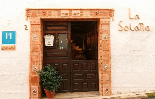 a door to a store with a potted plant in front at La Solana, alojamiento y alfarería in Arenas de San Pedro