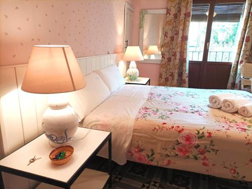 a bedroom with a bed with a lamp and towels at La Solana, alojamiento y alfarería in Arenas de San Pedro
