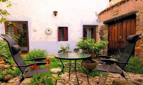 a patio with a table and chairs in front of a building at La Solana, alojamiento y alfarería in Arenas de San Pedro