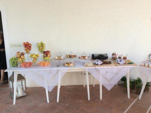 a white table with bowls of fruit on it at Borgo Dei Conti Della Torre in Morsano al Tagliano