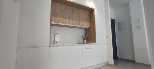 Una cocina con gabinetes blancos y un fregadero. en Mosaiko Apartments II, en Tarifa