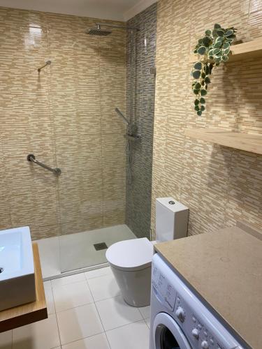 a bathroom with a shower and a toilet and a sink at bela vista apartamento in Estoril