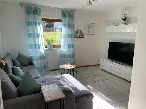 a living room with a couch and a tv at Haus Bärbel in Geisfeld