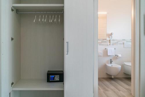a white bathroom with a sink and a toilet at Hotel Centrale in Lignano Sabbiadoro