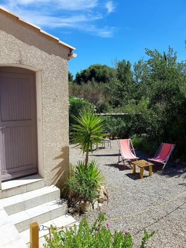 un groupe de chaises, une table et un bâtiment dans l'établissement Studio dans la Villa les Cigales, à Lézignan-Corbières