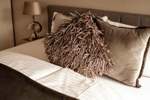 a stack of pillows on a bed next to a pillow at Boutique Hotel Villa Monika in Westerland